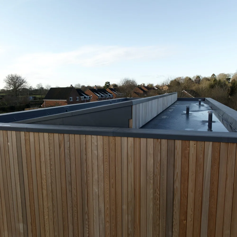 Building conversion exterior with vertical timber cladding and flat roof by Image Home Improvements
