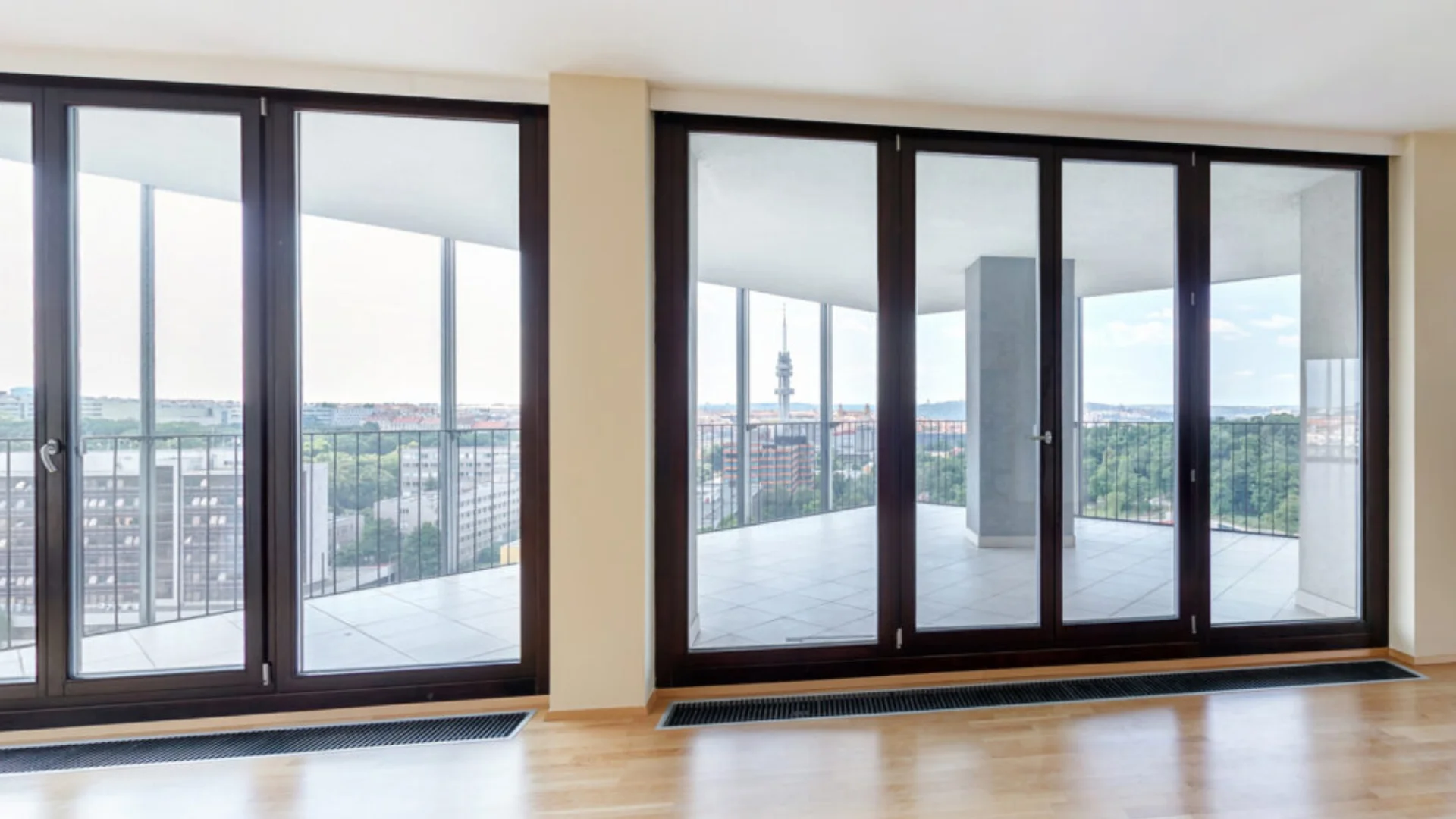 Large black framed bi-fold doors opening onto a balcony with city views.